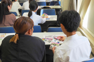 中学生のカードワークを見守る保護者